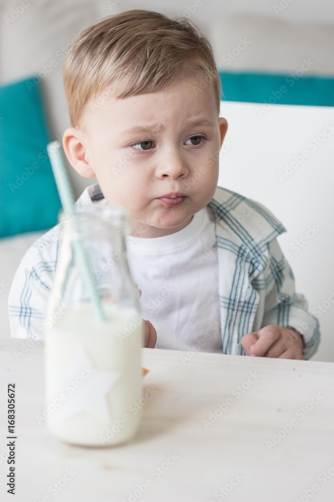 Сute little boy is eating candy and drinking milk. Health. Happy child. Breakfast. Сute little boy is eating candy and drinking milk. Health. Happy child. Breakfast.