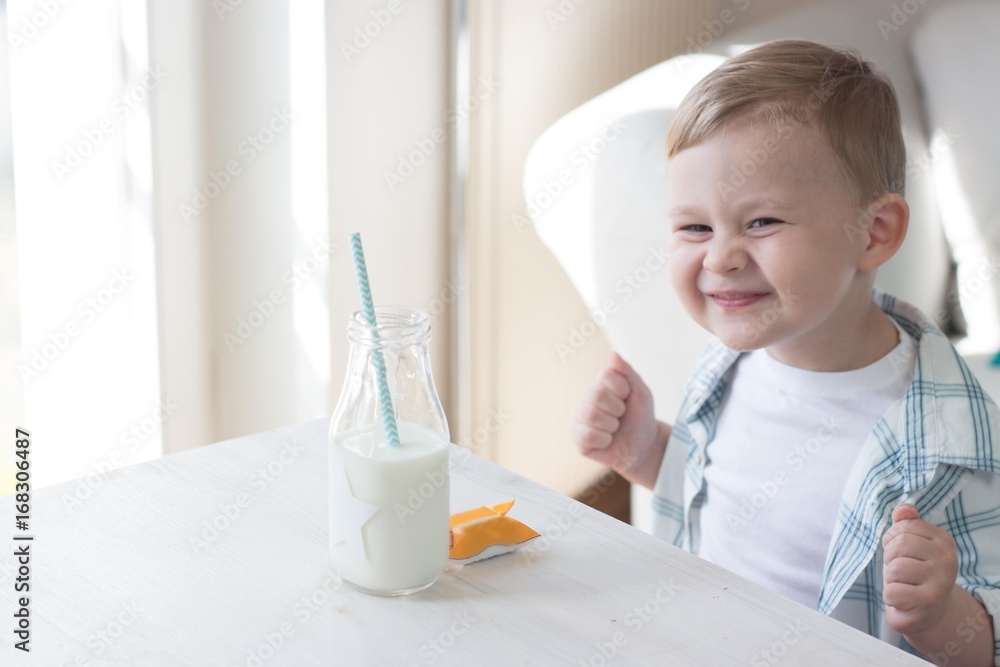 Сute little boy is eating candy and drinking milk. Health. Happy child. Breakfast. Сute little boy is eating candy and drinking milk. Health. Happy child. Breakfast.