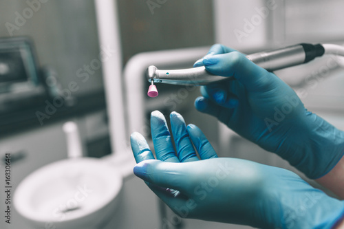 Detail of hand holding dental tools in dental clinic. Dentist Concept.