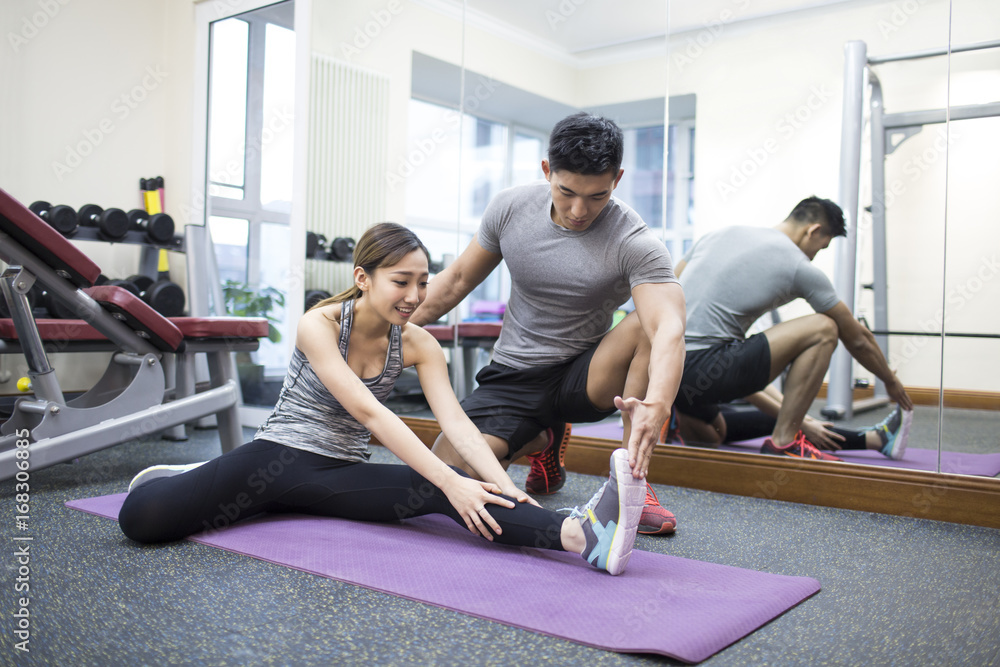 Young woman working out with trainer in gym Young woman working out with trainer in gym