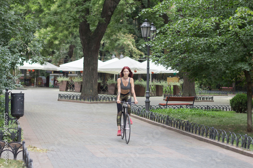 Wallpaper Mural Morning bicycle ride of young sexy woman with red hair, sporty female with black bicycle in park Torontodigital.ca