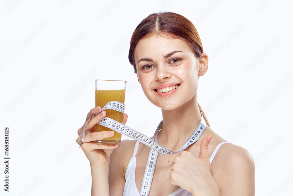 Young beautiful woman holds a glass of juice on white isolated background, portrait, smile, fitness Young beautiful woman holds a glass of juice on white isolated background, portrait, smile, fitness