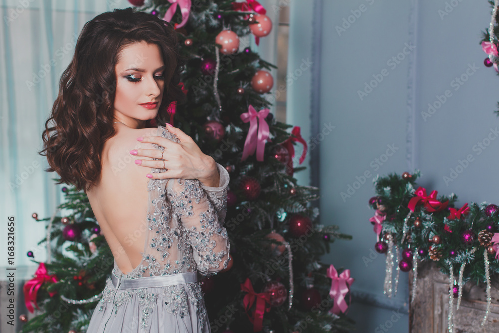 beautiful brunette in evening dress with naked back for Christmas. beautiful brunette in evening dress with naked back for Christmas.