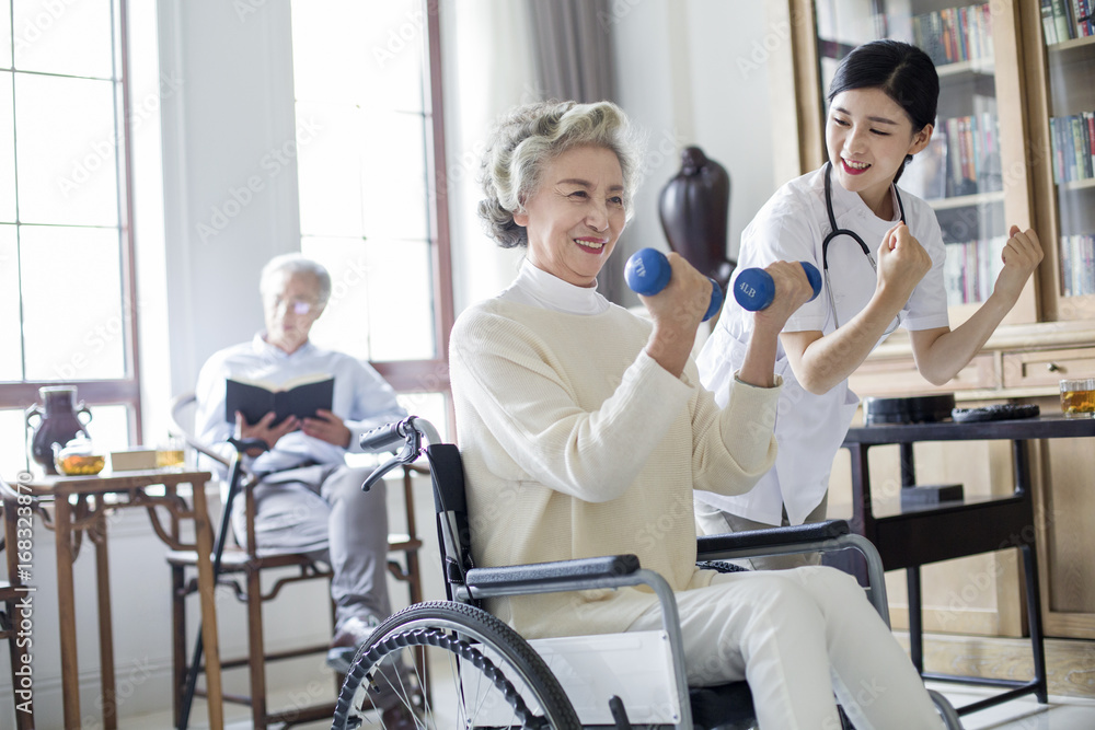 Senior woman exercising with dumbbell in nursing home Senior woman exercising with dumbbell in nursing home