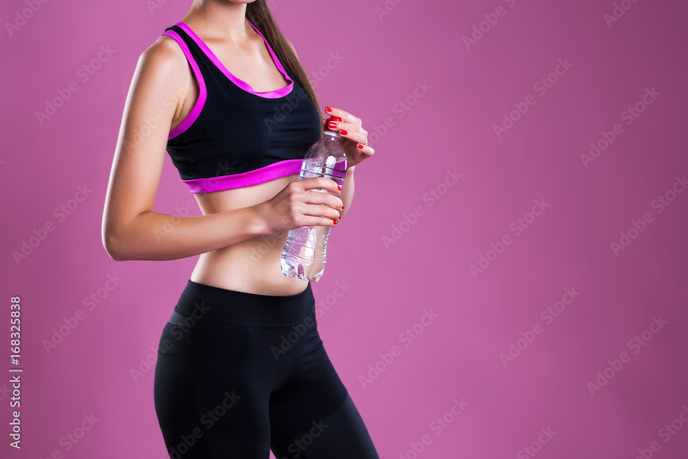 girl with perfect figure Keeps a bottle of water on pink background, space for text girl with perfect figure Keeps a bottle of water on pink background, space for text