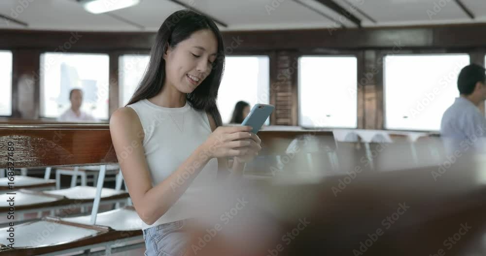 Woman use of smart phone in ferry of Hong Kong city Woman use of smart phone in ferry of Hong Kong city