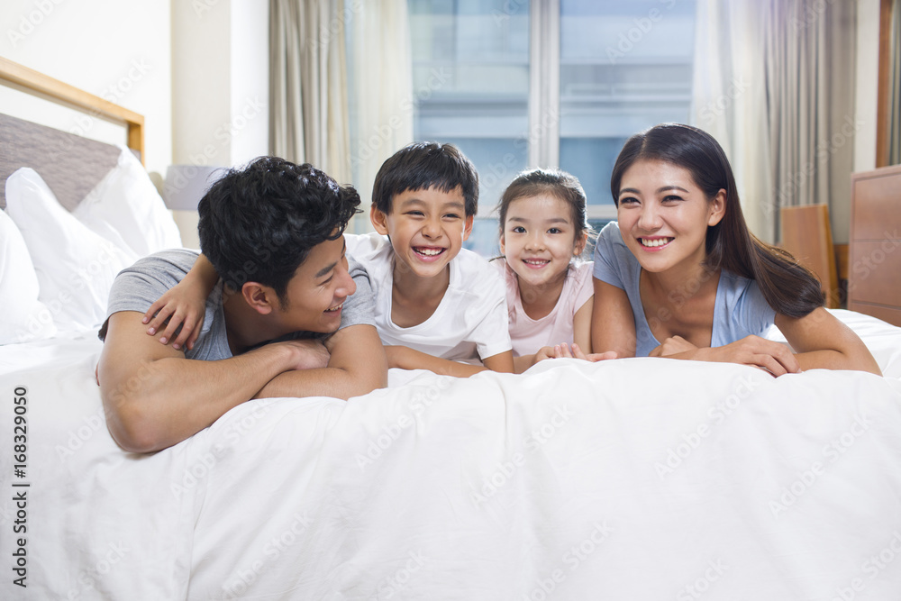 Cheerful young family on a bed Cheerful young family on a bed