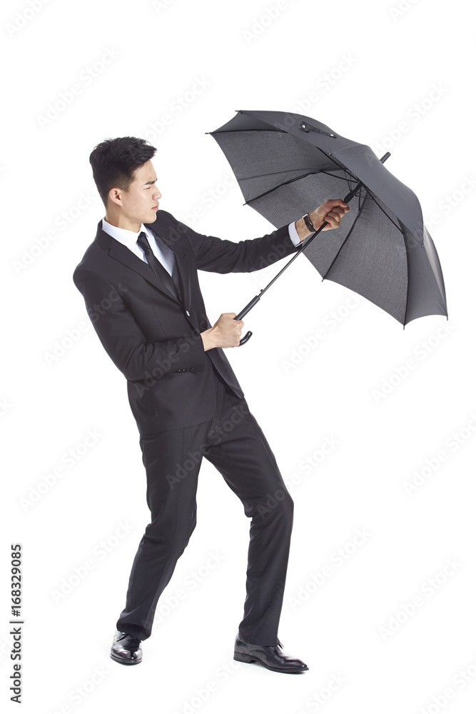 asian business man in suit and tie holding on to a black umbrella asian business man in suit and tie holding on to a black umbrella