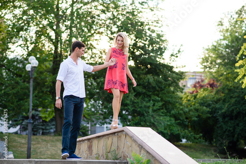 A guy with a girl holding hands in the Park.