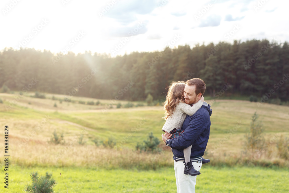 People, relationship, family, happiness concept. Happy father carrying his little daughter, feeling togetherness and love while having walk on green meadow. Cheerful dad and his cute small child People, relationship, family, happiness concept. Happy father carrying his little daughter, feeling togetherness and love while having walk on green meadow. Cheerful dad and his cute small child