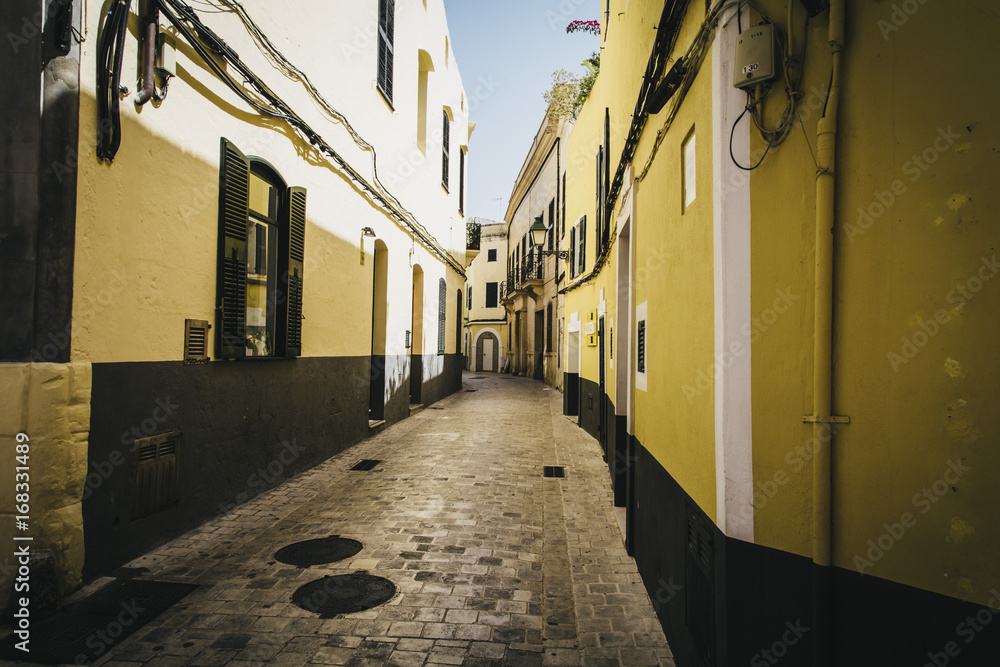 Yellow walls on a narrow cobble stones street