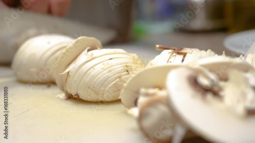 Chopping mushrooms with knife on chopping board
