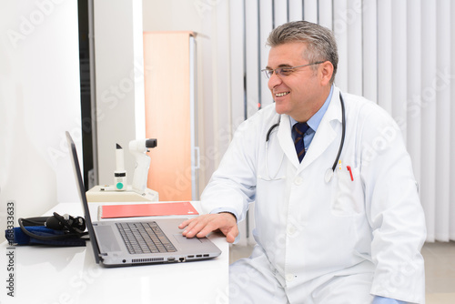 Doctor in his office with laptop