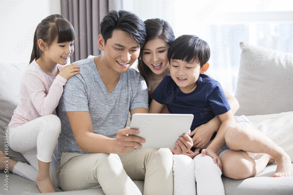 Happy young family using digital tablet at home Happy young family using digital tablet at home