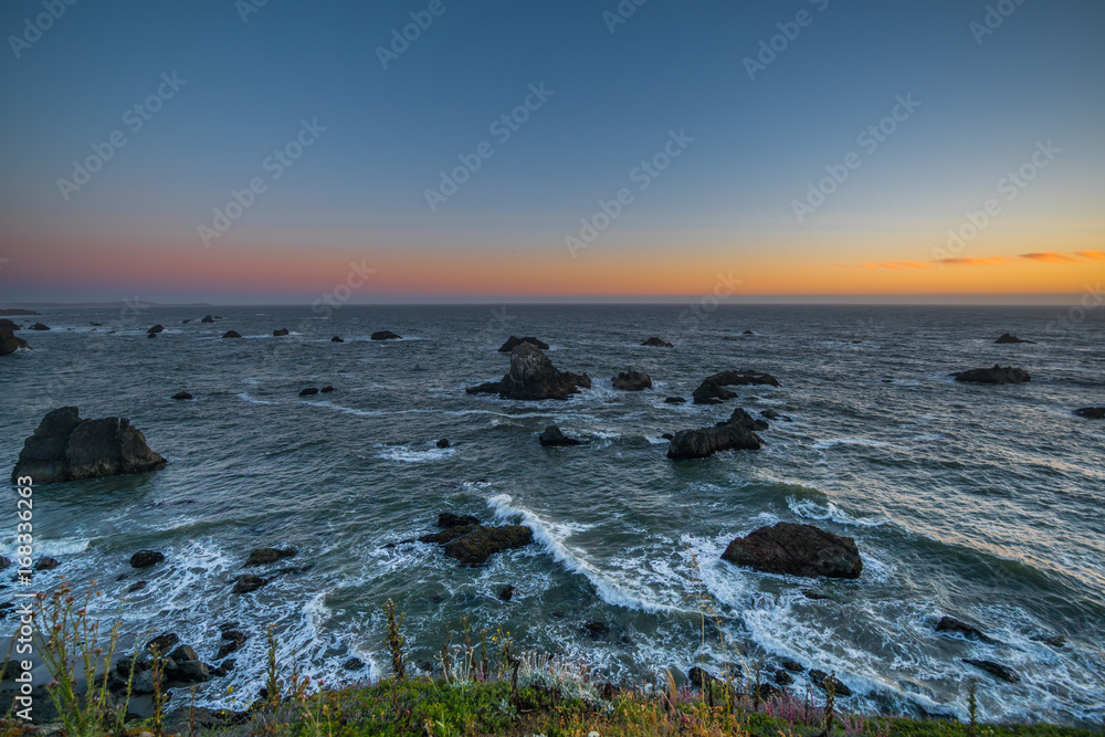Naklejka premium Marvellous sunset, amazing evening sky. Large boulder among the waves in the sea. Sonoma Coast State Park, California, USA