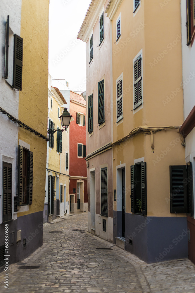 Narrow street in old town in Menorca, Spain