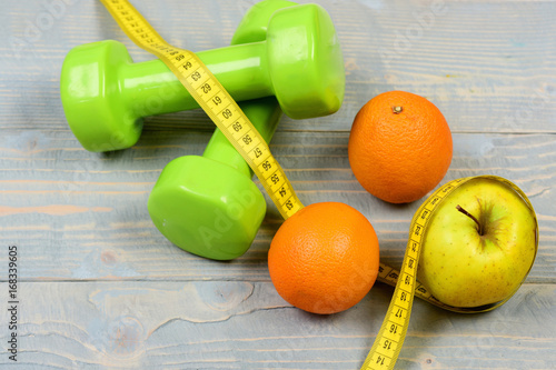 weight loss concept, dumbbells weight with measuring tape, fruit