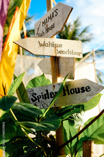 Wooden arrows signboards on the beach resort. Spider House. Wahine beach bar photo