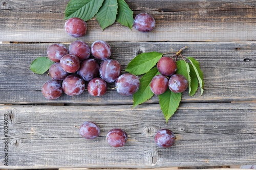Delicious fresh plums on wooden background view 