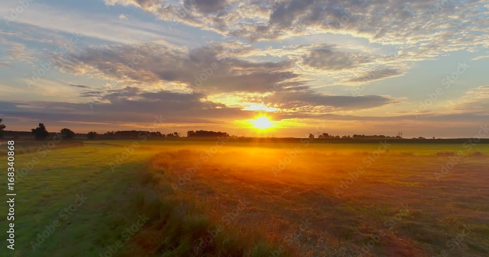 Amazing sunrise bursts through clouds over foggy Midwest farm fields.
Amazing sunrise bursts through clouds over foggy Midwest farm fields.