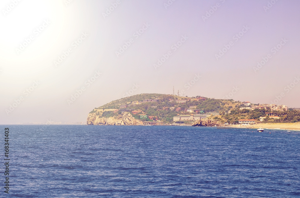 View from the sea to the city and the beach in sunlight. Toned
