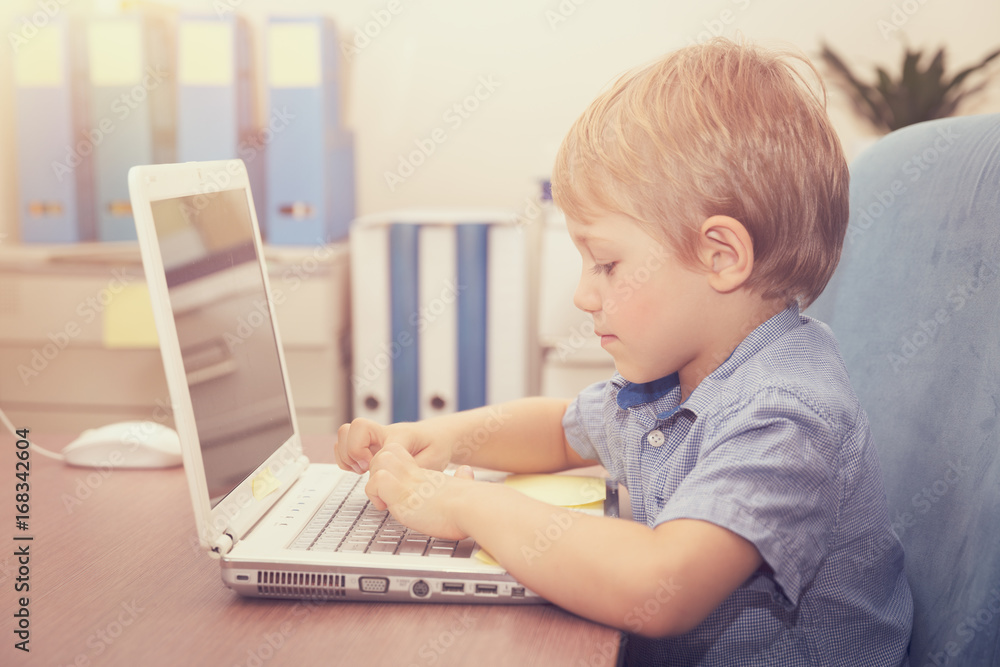 Little boy working on the laptop Little boy working on the laptop
