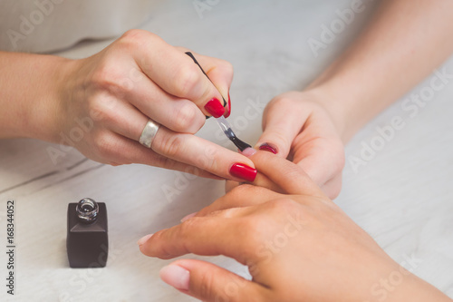 The manicurist paints the nails of women