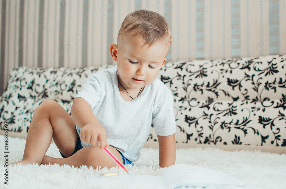 Little baby boy thoughtfully draws or writes pen Little baby boy thoughtfully draws or writes pen
