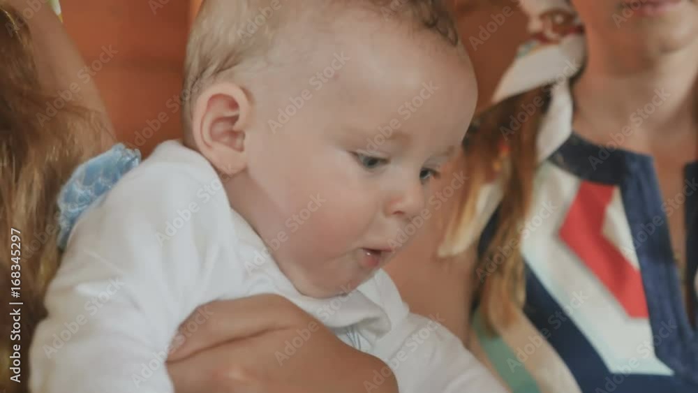 The child moves quickly and smiles during the rite of baptism