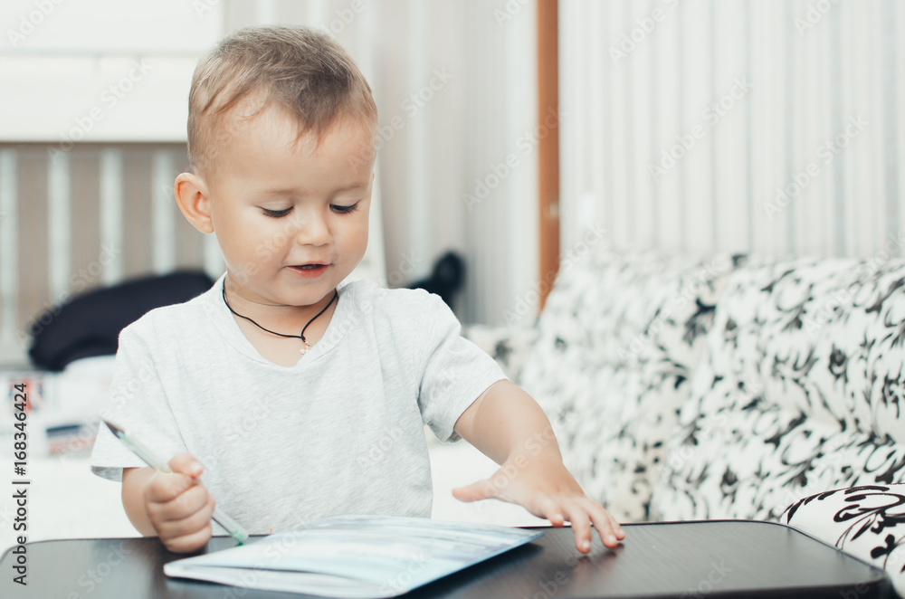 Little baby boy thoughtfully draws or writes pen Little baby boy thoughtfully draws or writes pen