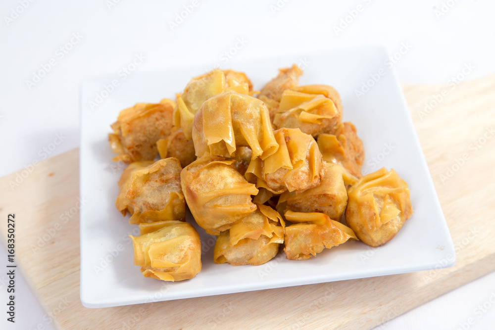 Deep fried wonton or fried dumplings cuisine on white plate Deep fried wonton or fried dumplings cuisine on white plate