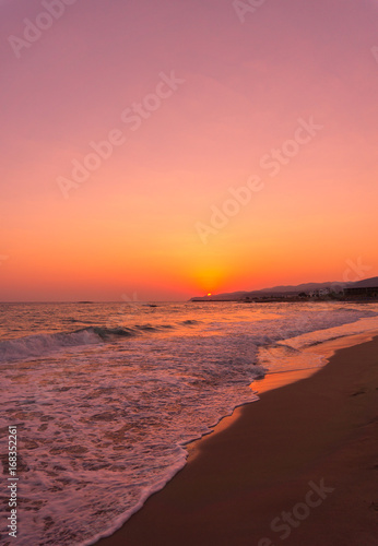 Blick auf menschenleeren Strand im warmen Licht eines Sonnenaufgang 