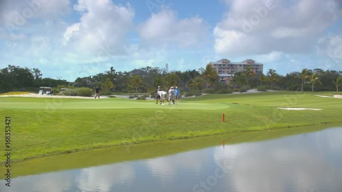 Nassau Bahamas Tourists Playing Golf in a Tropical Setting at Royal Blue Course at Baha Mar Hotel Resort and Casino photo