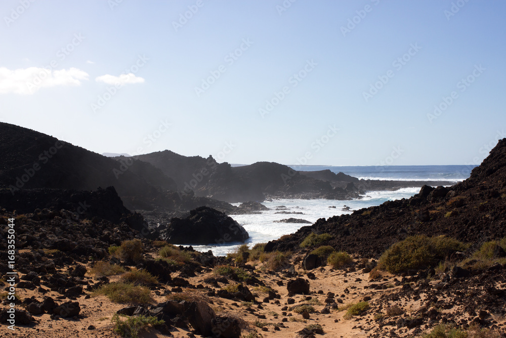Panoramic ocean view. Volcano, black rocks. Sand macro. Sea background. Horizon.