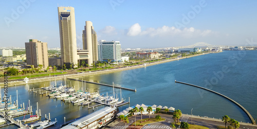Panorama aerial view Bayfront area of Corpus Christi with skylines and marina piers row of boat, sailboat and yacht at sunrise. City harbor bridge far right in distance. A Texas city on Gulf of Mexico photo