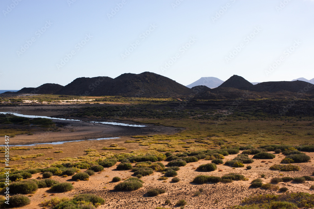 Panoramic ocean view. Volcano, black rocks. Sand macro. Sea background. Horizon. Panoramic ocean view. Volcano, black rocks. Sand macro. Sea background. Horizon.