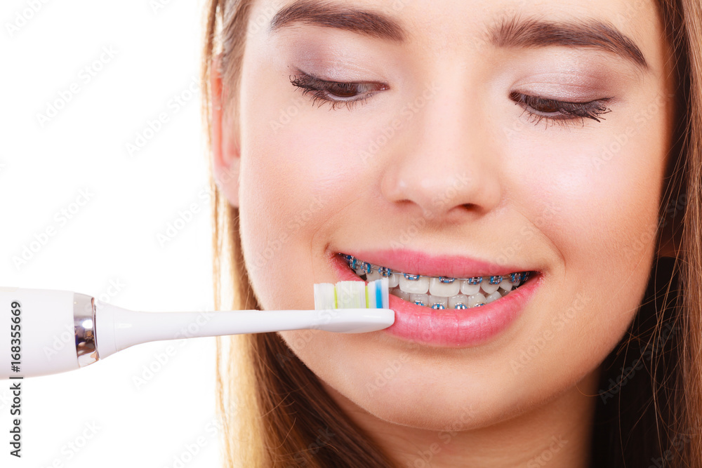 Woman brushing teeth with braces using brush Woman brushing teeth with braces using brush