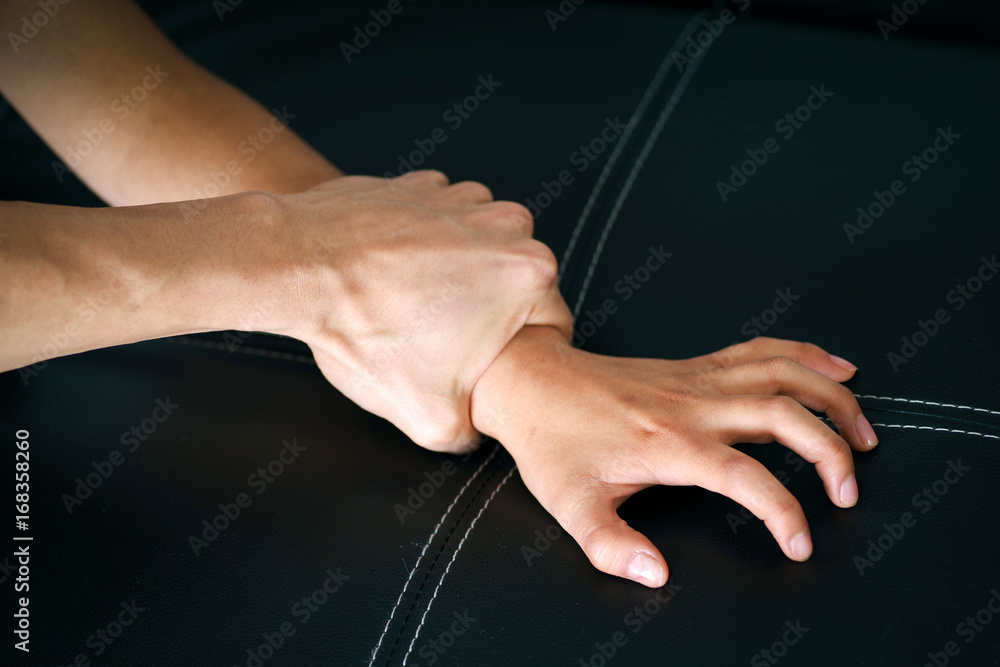 Close up man's hand holding a woman wrist over a black coach for rape and sexual abuse concept