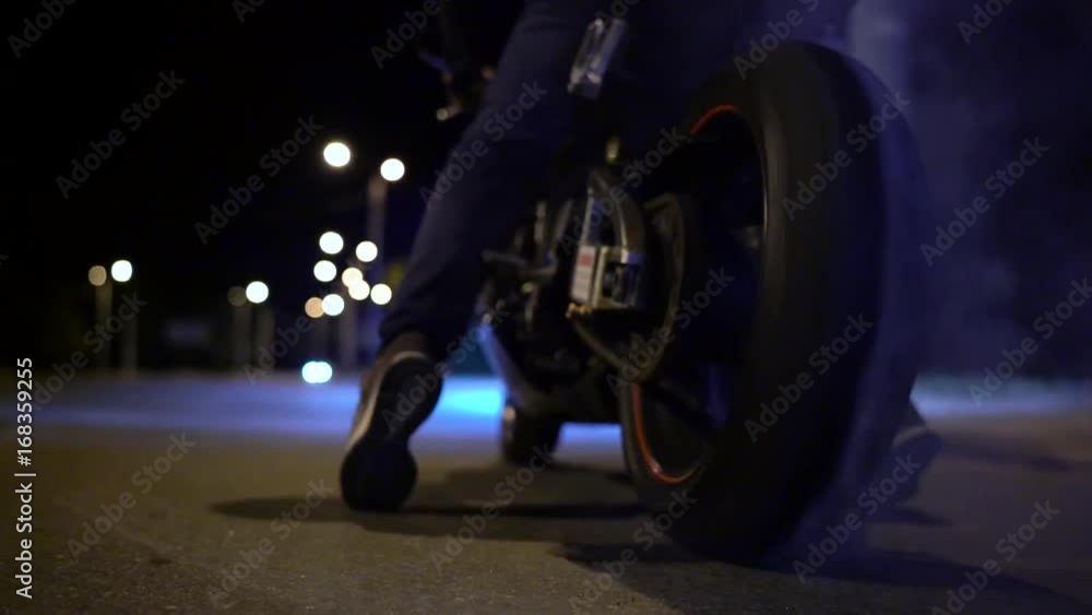 Man doing a tire burnout on motorcycle on the city road at night. Slow motion Man doing a tire burnout on motorcycle on the city road at night. Slow motion