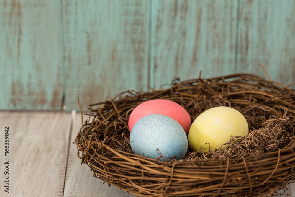 Obraz premium Three Colorful Easter Eggs in a Nest