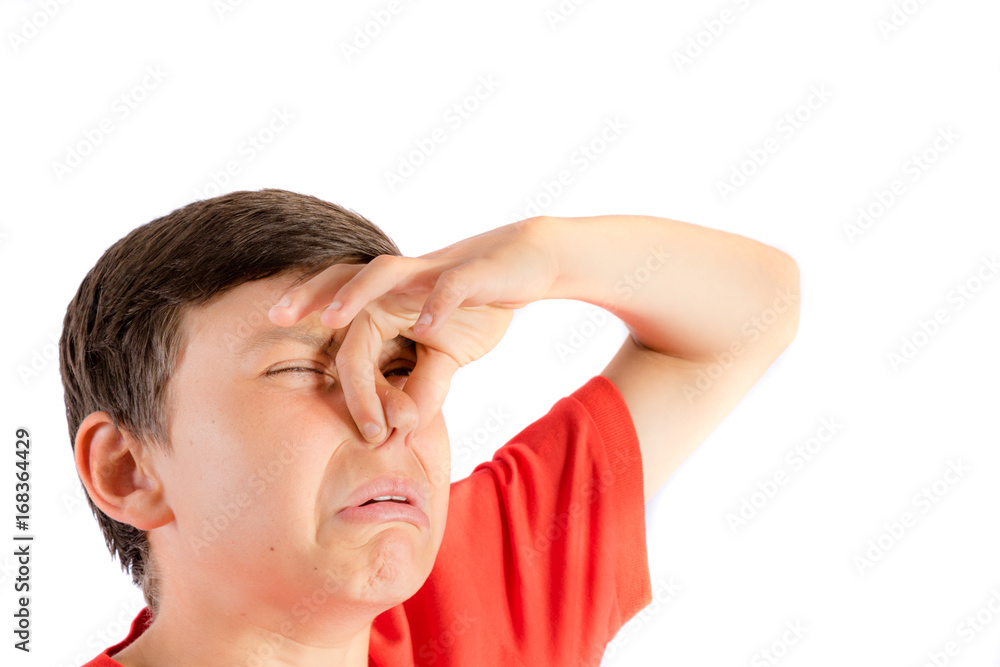 Young teenage boy isolated on a white background holding his nose Young teenage boy isolated on a white background holding his nose