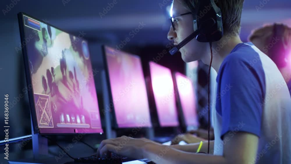 Team of Professional eSport Gamers Playing in Competitive MMORPG/ Strategy Video Game on a Cyber Games Tournament. They Talk to Each other into Microphones. Arena Looks Cool with Neon Lights. Team of Professional eSport Gamers Playing in Competitive MMORPG/ Strategy Video Game on a Cyber Games Tournament. They Talk to Each other into Microphones. Arena Looks Cool with Neon Lights.