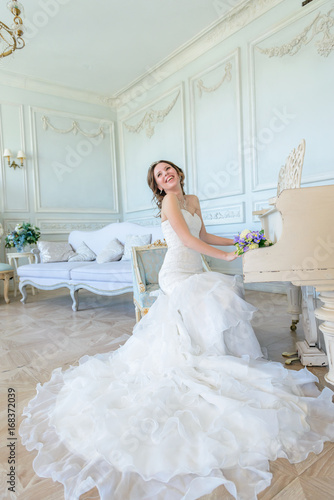 Young attractive bride on wedding gown in studio
