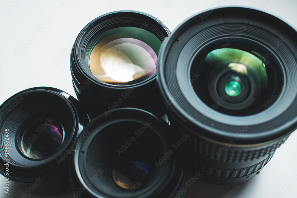 close-up view of a group of camera lenses on a white surface close-up view of a group of camera lenses on a white surface