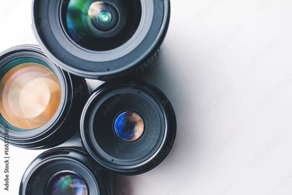 close-up view of a group of camera lenses on a white surface close-up view of a group of camera lenses on a white surface