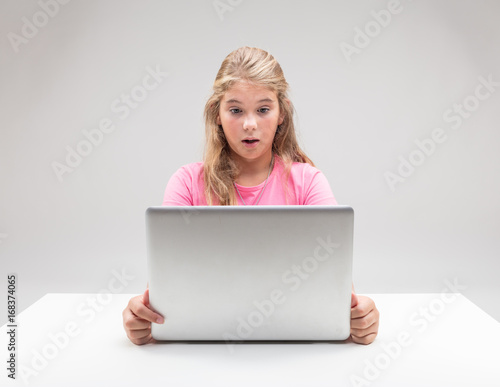 blonde little girl surprised at her computer