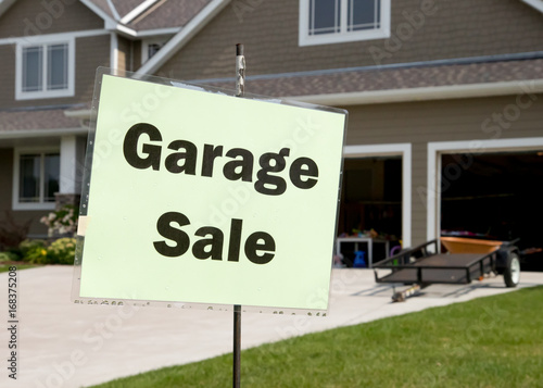 Garage sale sign in front of suburban garage