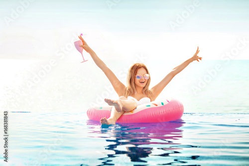 Summer Vacation. Woman in bikini on the inflatable donut mattress in the SPA swimming pool.