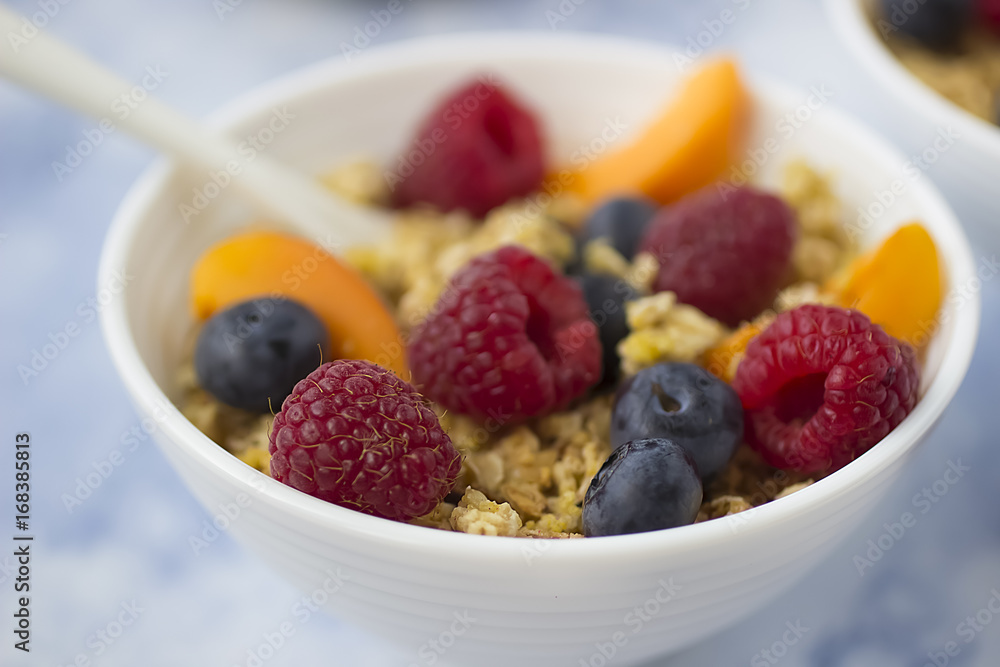 Bowls of granola with fresh fruit on marble table. Bowls of granola with fresh fruit on marble table.