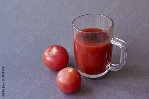 Tomato juice in glass and fresh tomatoes photo